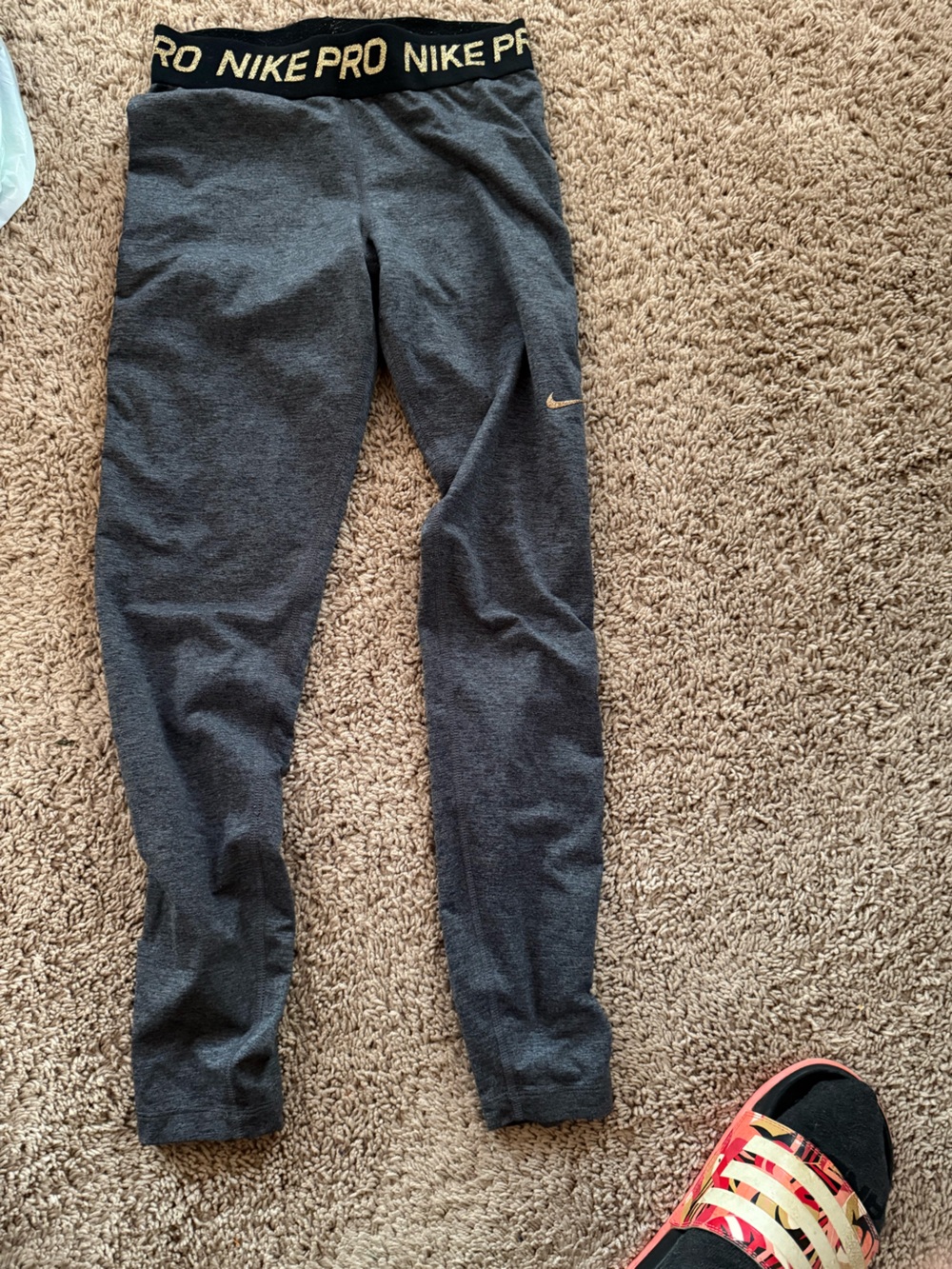 Nike women’s Charcoal Gray leggings with gold Swoosh